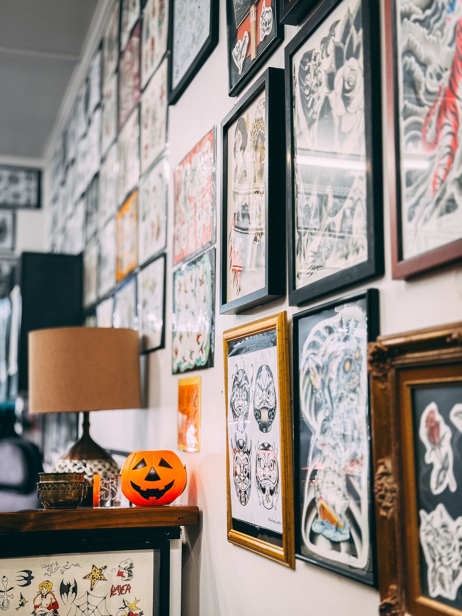 Framed tattoo flash covering a shop wall